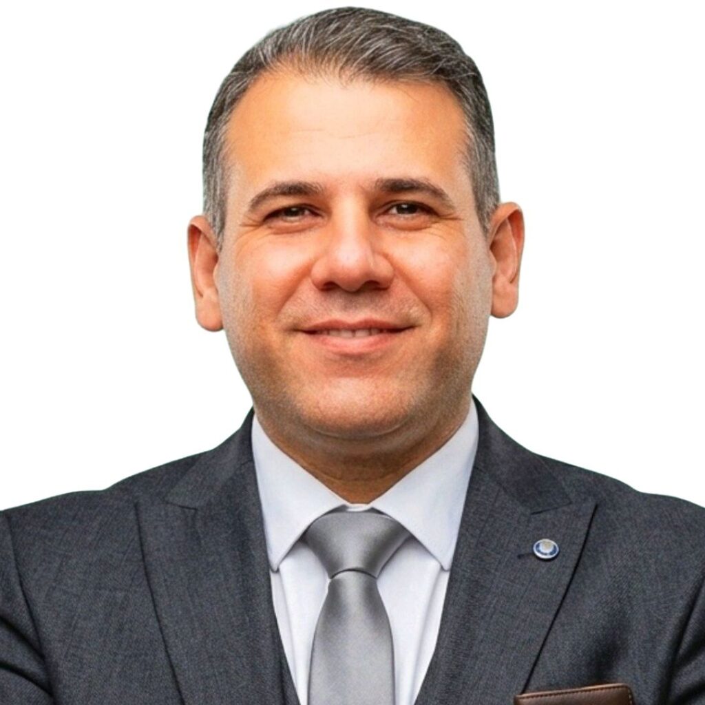 Abu Zeid Al-Shalabi smiling, wearing a grey suit and tie